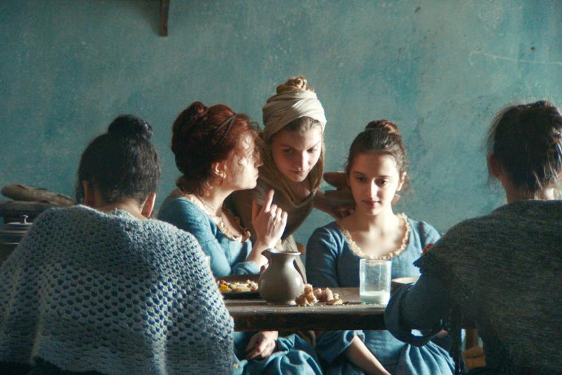 Screenshot aus dem Film "Gloria!". Drei junge Frauen flüstern sich etwas ins Ohr.  © Neue Visionen Filmverleih 